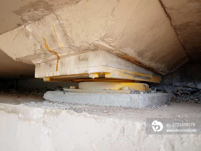 Pot bearing on beam under bridge. It is installed on a concrete beam to support and distribute the weight from the bridge to the bridge pier. Focus close and choose the subject.