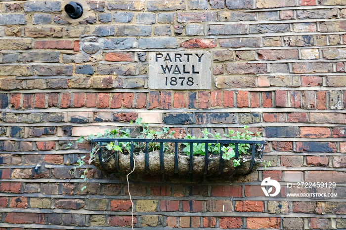 Old brick wall with planter and sick indicating Party Wall 1878