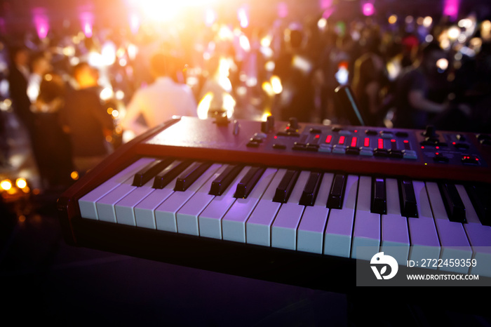 Piano keys in purple light on concert stage. Synthesizer.