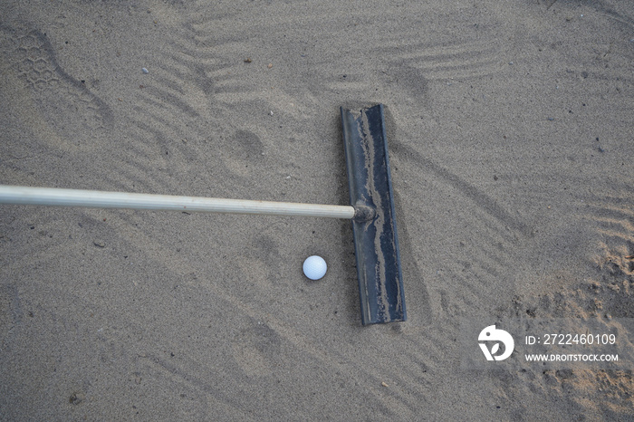 Golf concept. Golf ball and rake sand on bunker in beautiful golf course at sunset background