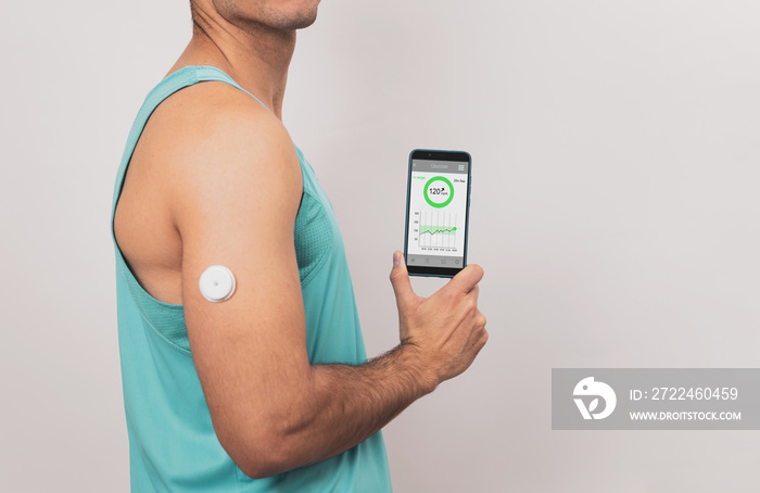 Unrecognizable young man shows his mobile with glucose monitor continuous blood sugar test app, glucose measurement, White background.