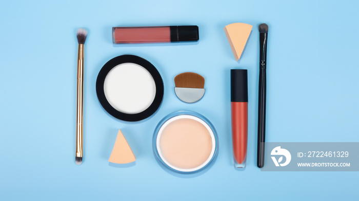 set of professional decorative cosmetics, make-up products and accessories on blue background. Beauty, fashion and shopping concept. flat lay. top view