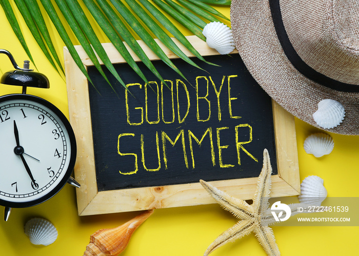 Goodbye Summer Text. Alarm Clock, Starfish, Fedora Hat, Palm Leaf, Sea Shells and Blackboard Room for Text. Flat Lay Traveling Holiday Vacation Yellow Background