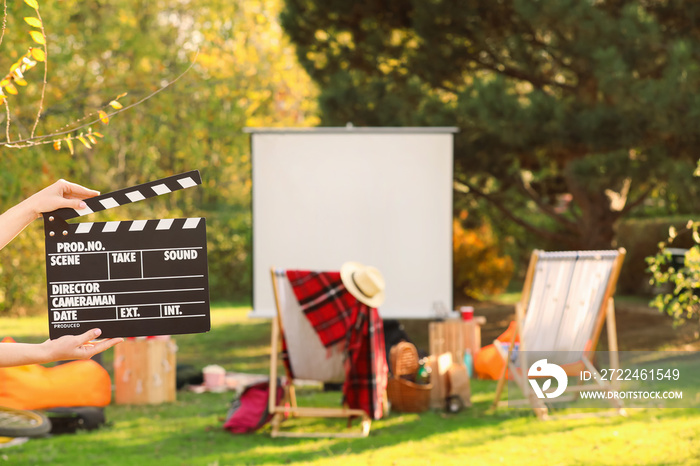 Woman with movie clapper in outdoor cinema