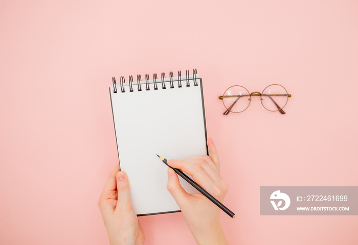 Female hand holding pencil and sketchbook. Mock-up Concept. Bright background, isolated, close up