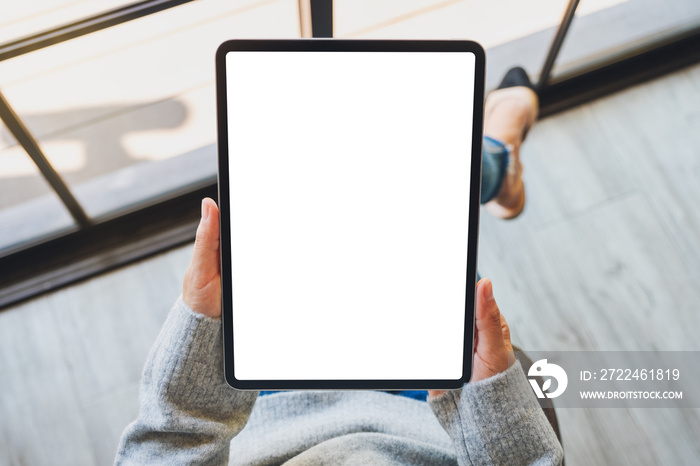 Top view mockup image of a woman holding black tablet pc with blank white screen