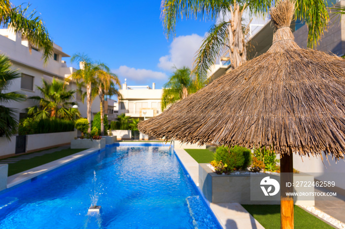 Pool in a condominium with blue water on a sunny day.