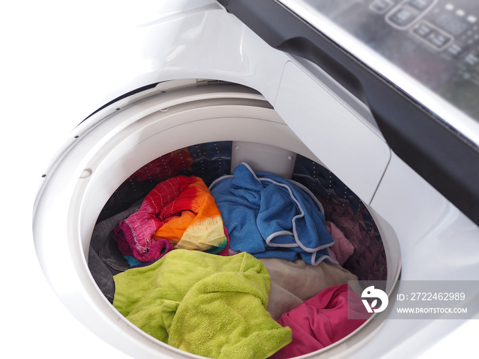 Top view of white washing machine with clothes