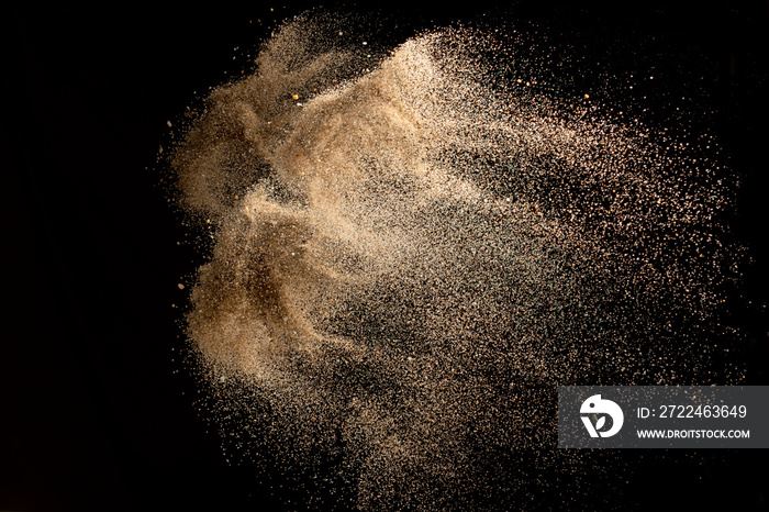 Abstract sand explosion art on black background, sand splash.