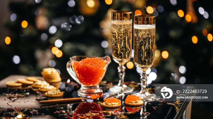 Elegant glass of champagne with red caviar on golden spoon and glass container of caviar, Gourmet food close up, appetizer, selective focus, place for text