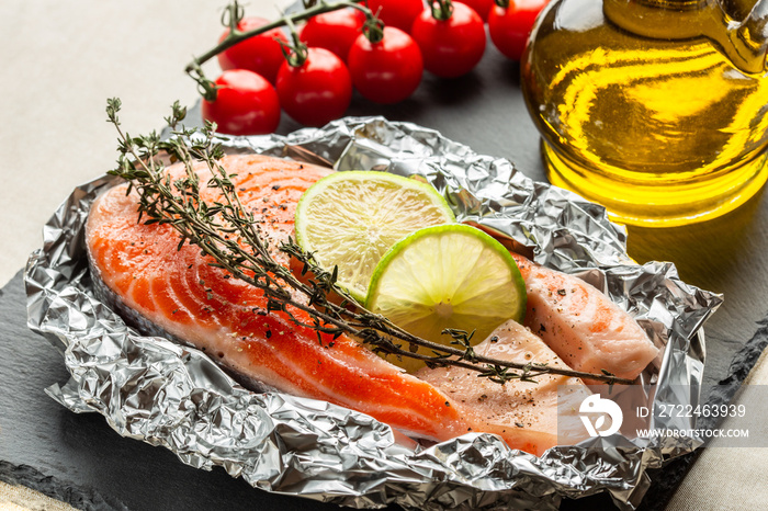 Raw fish with thyme and lime in foil ready for baking