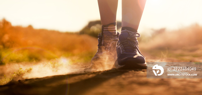 Female athletic legs and dust from the trail close up.