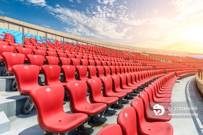 Red seats and beautiful sky clouds in the stadium