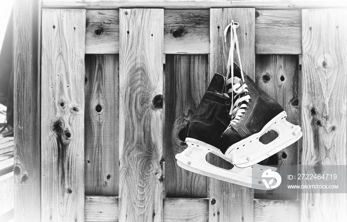 Hockey skates hanging on outdoor wooden planks