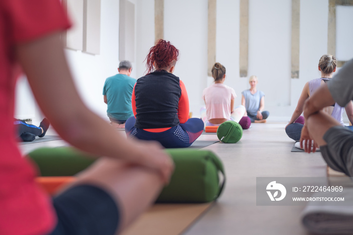 Back photos of a yoga class, with people of different ages.