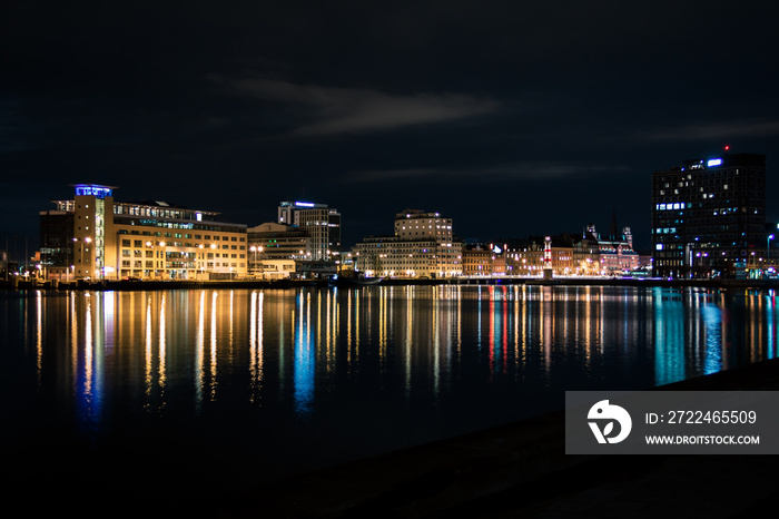 Skyline of Malmö Sweden seen from the water with lights reflecting