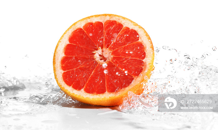 Fresh grapefruit in splashing water isolated on white