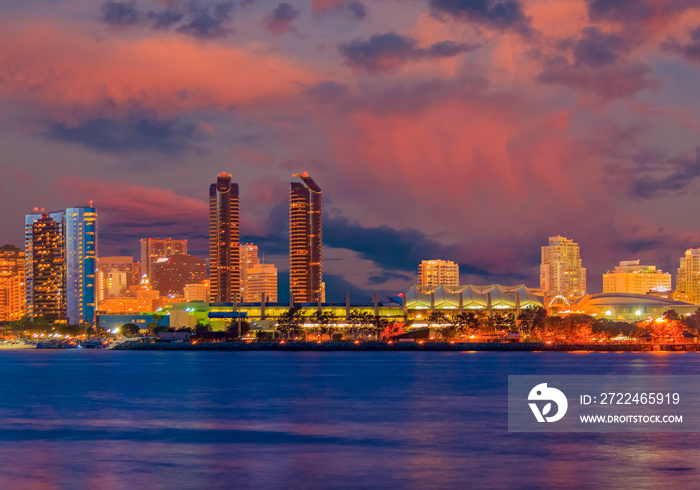 San Diego Bay at night with city lights reflected in water all glow in the sunset.