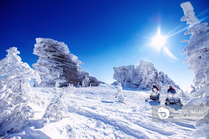 Polar arctic snow mountains with sun light. Concept travel tourist group snowmobile tour in frozen forest