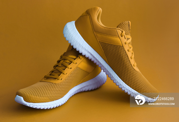 Colorful sport shoes on mustard color backround. Modern fashion sneakers print concept