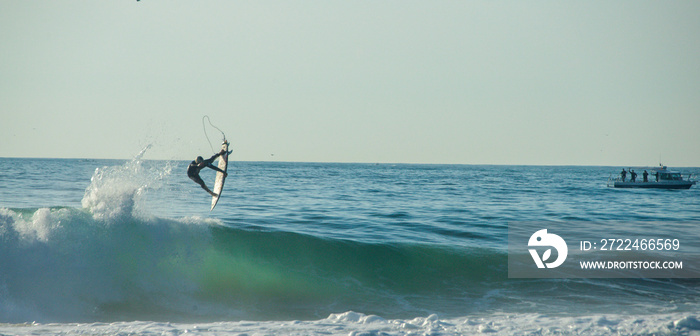 Surfer athletes riding the crazy blue waves of Portugal