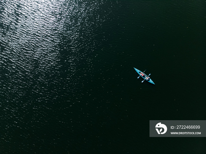 A drone shooting a kayak floating in the water.