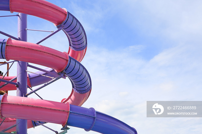 Detail of serpentines of the tubes of a water slide of swimming pool against sky background.