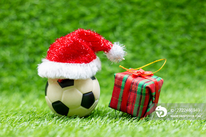 Soccer ball with Christmas Decoration are on green grass background