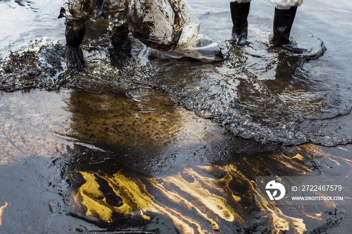 Workers remove and clean up crude oil spilled from Prao Bay