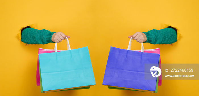 Female hand holds a paper disposable bag with handles for groceries and clothes.