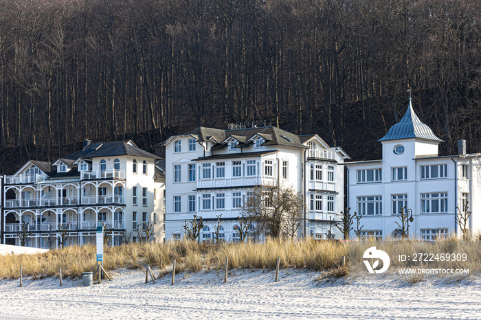 Luxury hotels along the sandy shore near the forest.