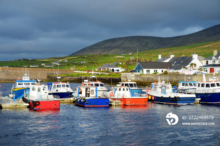 Colorful fishing boats and yachts at the harbor of Portmagee town on the West Atlantic coast of Ireland.