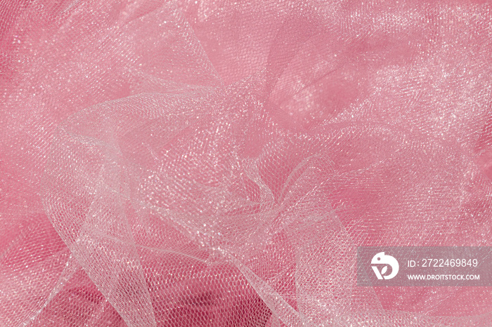 Pink tulle fabric texture top view. Coral background. Fashion color trends feminine tutu skirt flat lay, female blog backdrop for text signs desidgn. Girly abstract wallpaper, textile surface.