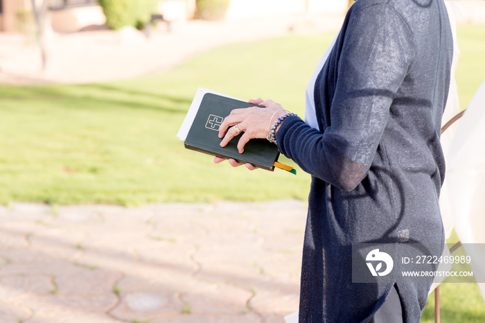 female minister preacher holding bible at wedding ceremony