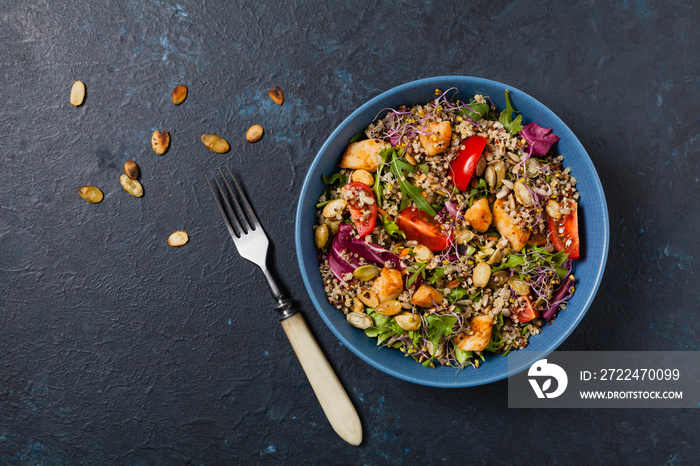 Salad with quinoa, avocado and chicken. Top view. Served in a blue bowl.