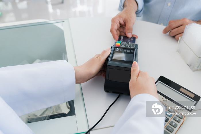 Payment by credit card with payment terminal in qualified drugstore or hospital. Modern payment of electric money. Closeup customer purchase medication in pharmacy with credit card on pos.