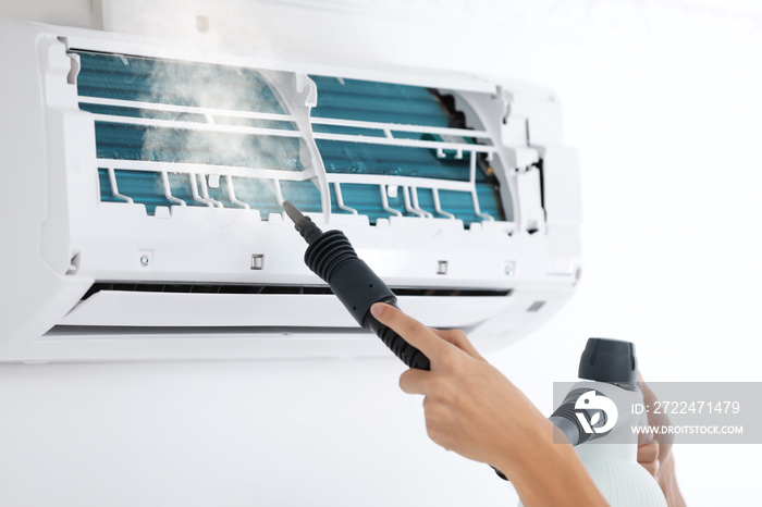 Man cleaning air conditioner indoors