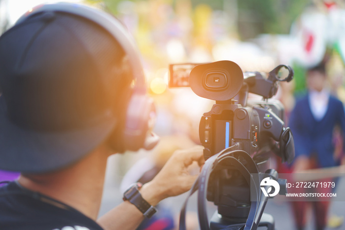 Videographer or operator shoots on Video camera with a transmitting device over Wi-Fi,Video production, headphones. live stream.  Cameraman using professional digital video camera. Outdoor setup