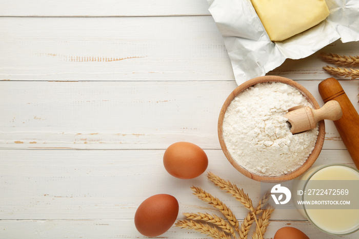 Ingredients for baking or cooking, egg flour, rolling pin butter, milk on a white wooden background Cookie pie or cake recipe.