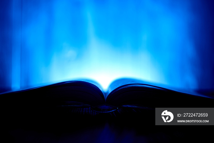 An open book with a glow in the background.