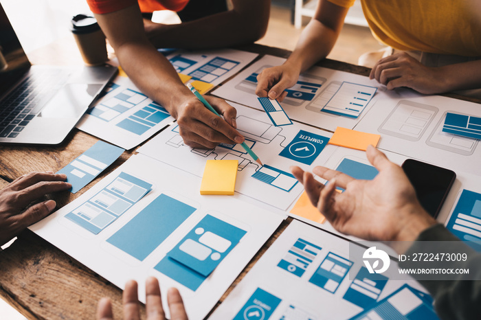 Ux developer and ui designer brainstorming about mobile app interface wireframe design on table with customer breif and color code at modern office.Creative digital development agency