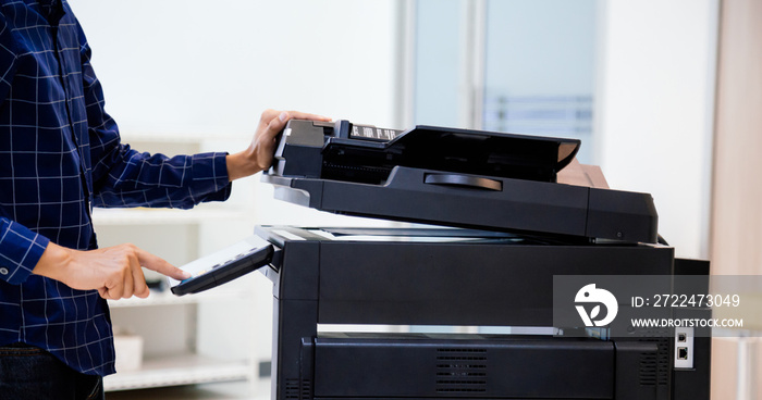 Businessmen press button on the panel for using photocopier or printer for printout and scanning document paper at office.