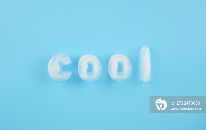Cool ice alphabet made of ice cubes on blue background.