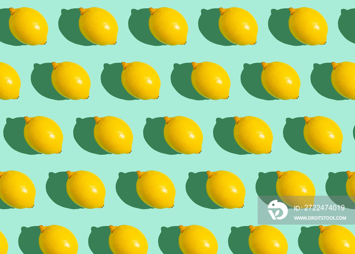 Fresh yellow whole lemons on minimal blue background on bright sun light with hard shadows pattern summer background flat lay from above, citrus food composition, space for text