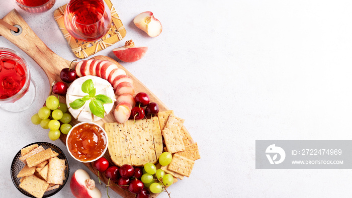 Healthy mediterranean cheese and fruits board with rose wine on light background