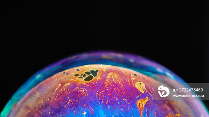 Virtual reality space with abstract multicolor psychedelic planet. Closeup Soap bubble like an alien planet on black background