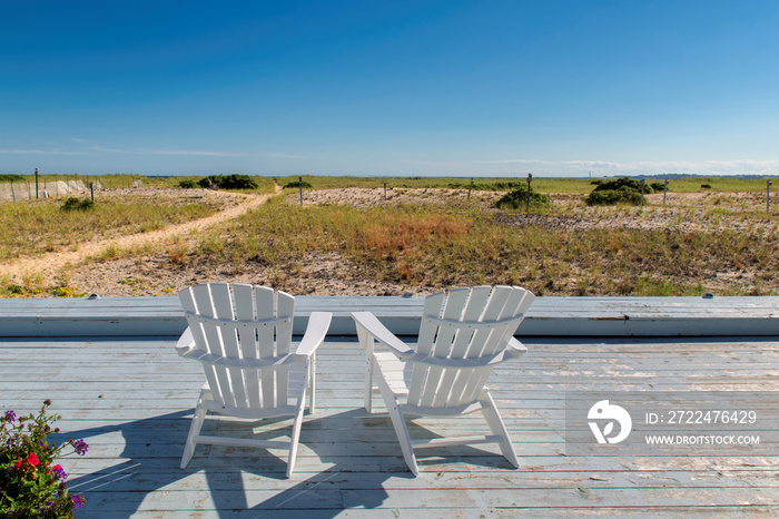 Cape Cod beach at sunset with beach chairs on, Cape Cod, Massachusetts, USA.