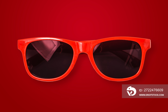 Red sunglasses on red background