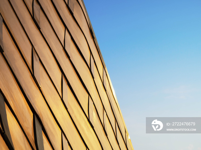 View of metal copper building, Curve architectural design, Abstract facade of architecture skin on blue sky background.