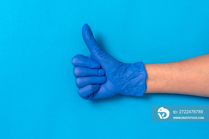 Hand in a blue rubber glove with thumb up